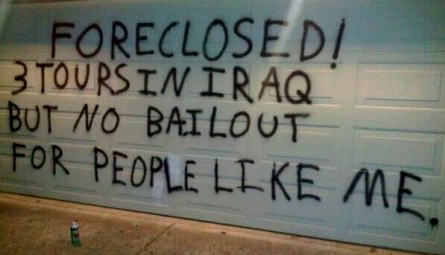 Photo of Verteran's writing on a wall, "Foreclosed! 3 tours in Iraq but no bailout for people like me."